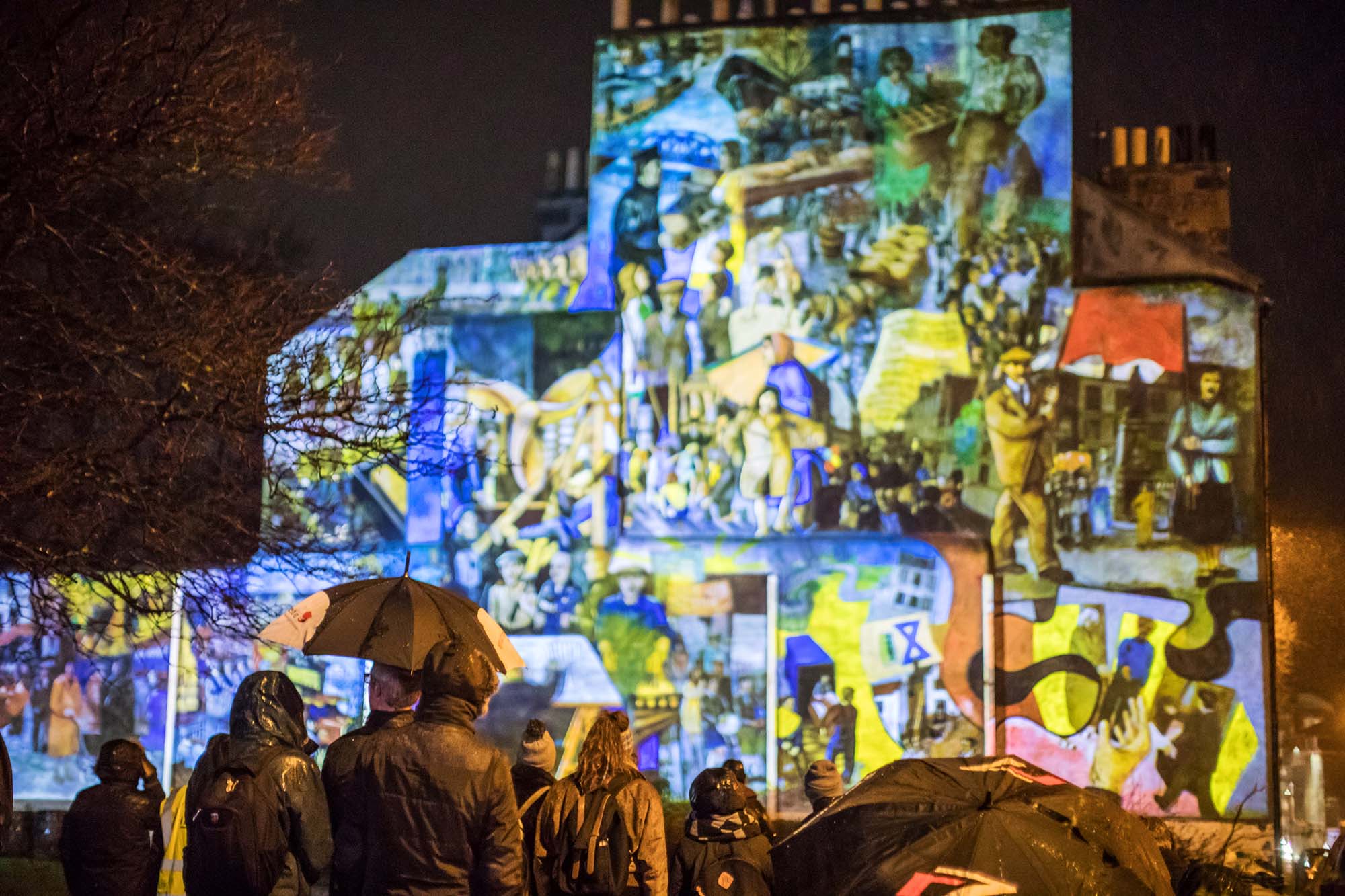 audience standing in front of leith mural projection