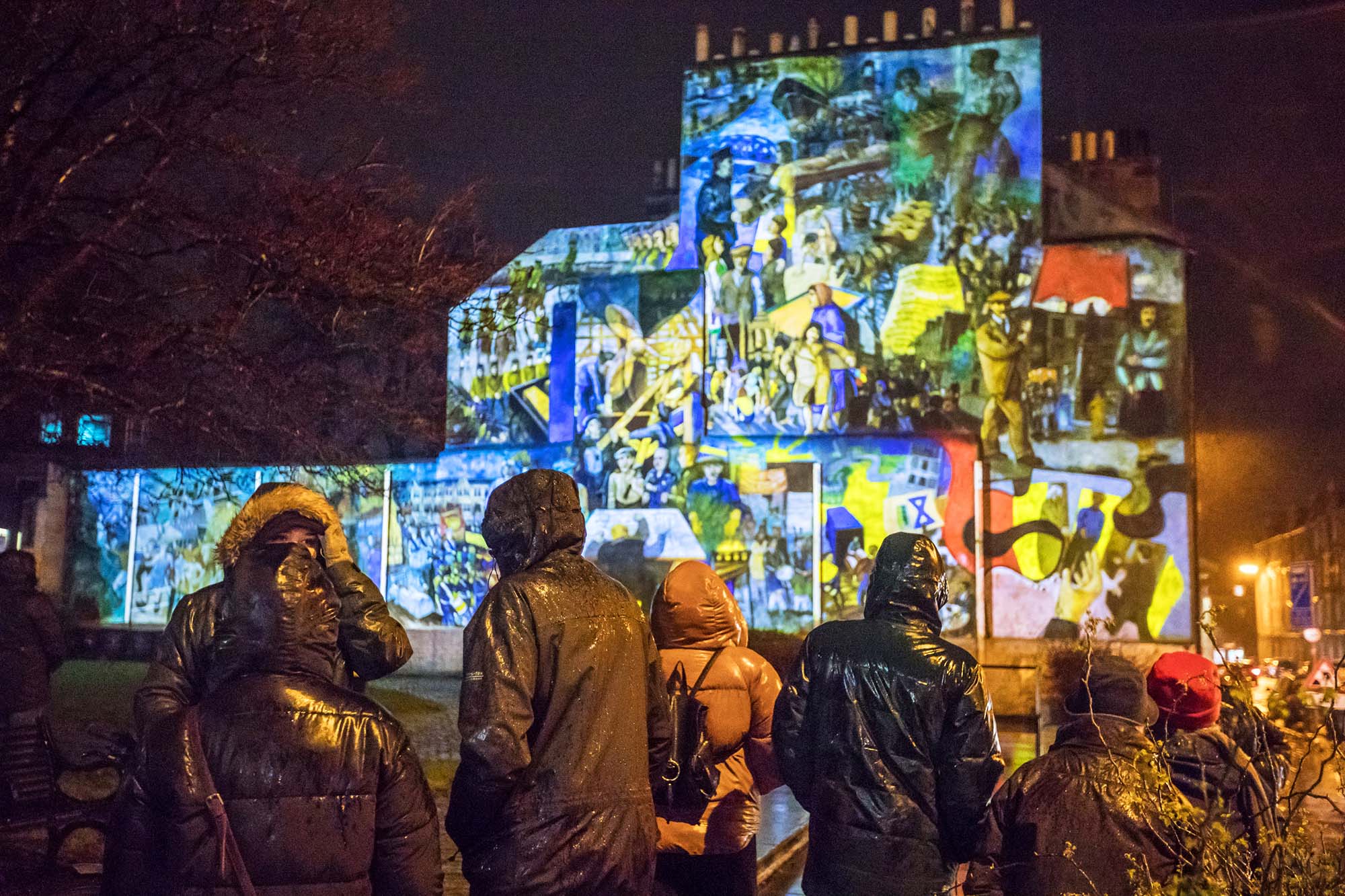 audience standing in front of leith mural projection