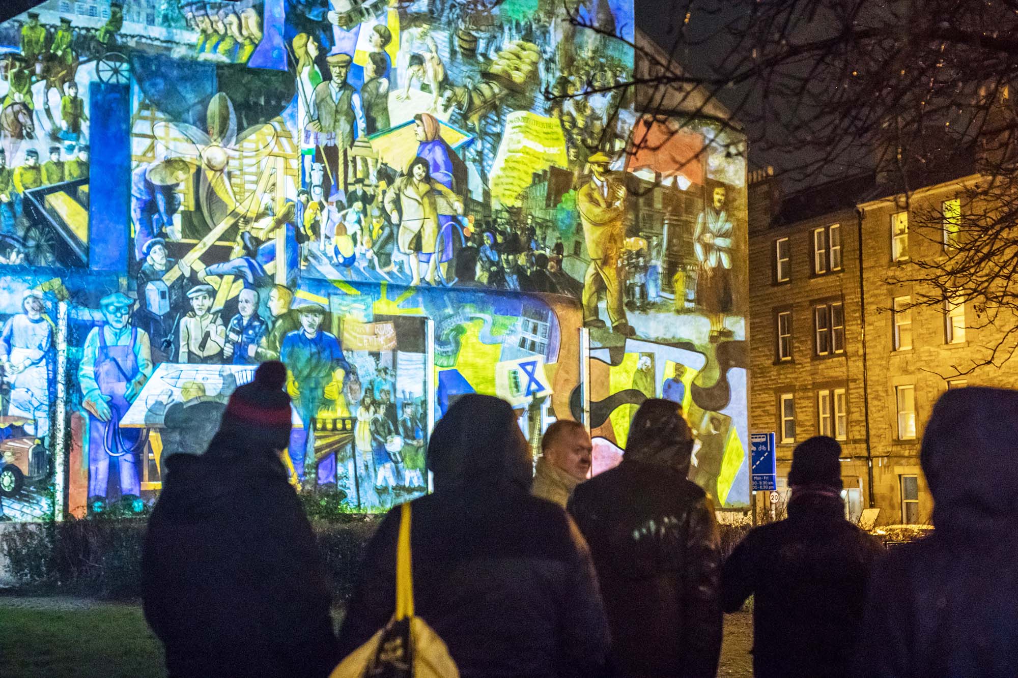 crowd standing in front of leith mural projection